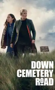 Empty Down Cemetery Road sign on rural grass field with two women walking nearby.
